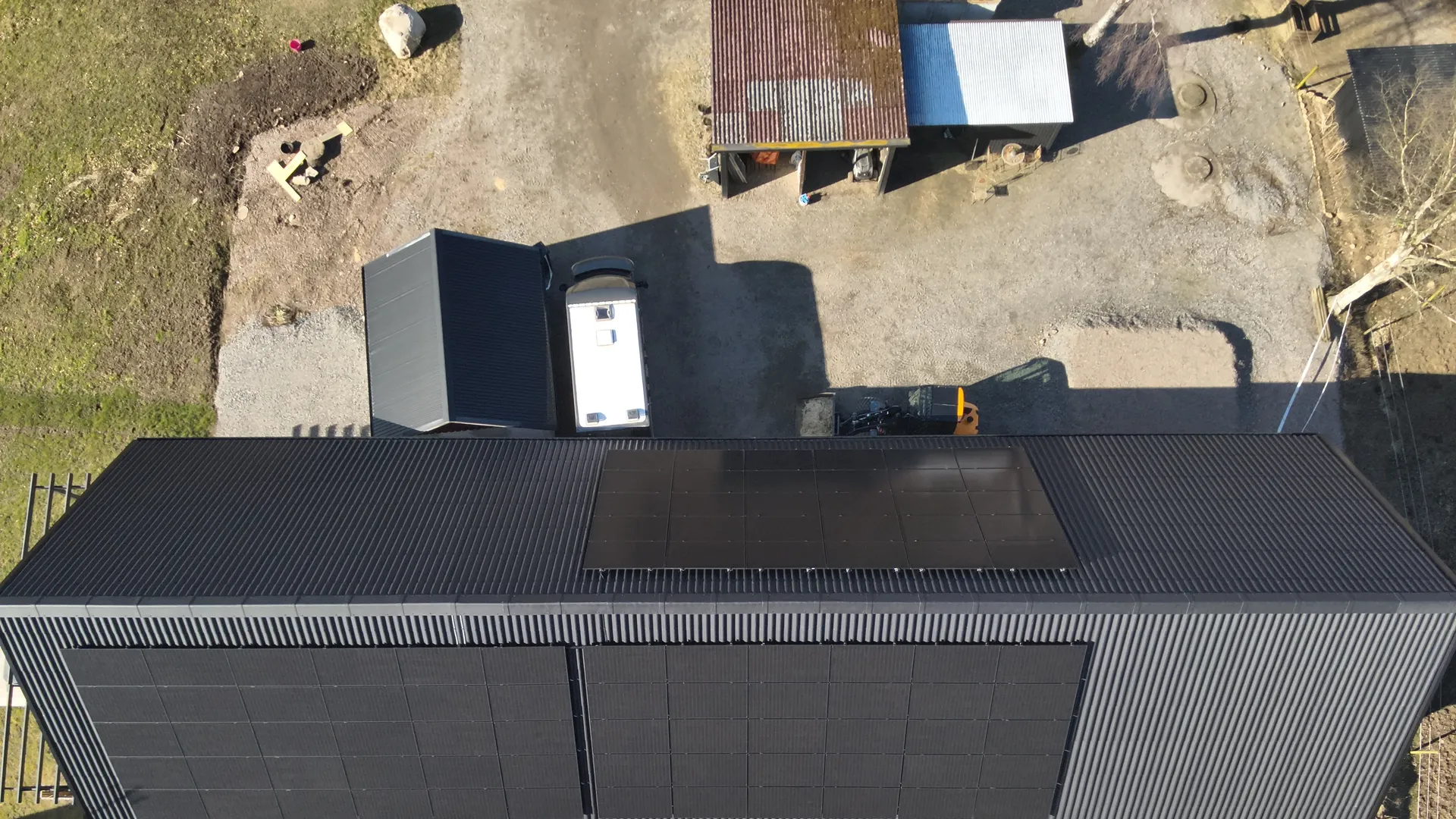 Flygbild över en lantbruksbyggnad med solceller på tak och fasad